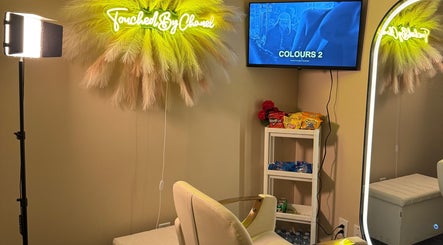 Cozy salon chair with neon TouchedByChanel sign in Montréal, Québec, CA.