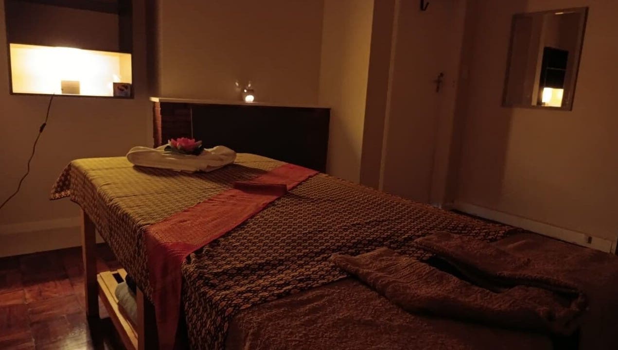 Relaxing massage room at Dok Koon Thai Massage and Wellness Spa, Cape Town, Western Cape, ZA, with warm lighting.