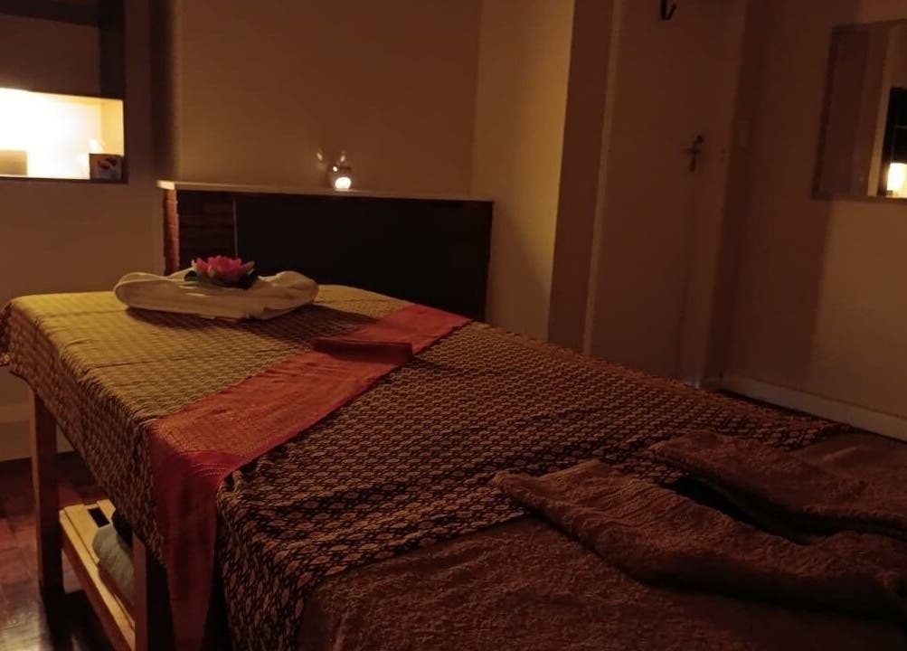 Relaxing massage room at Dok Koon Thai Massage and Wellness Spa, Cape Town, Western Cape, ZA, with warm lighting.