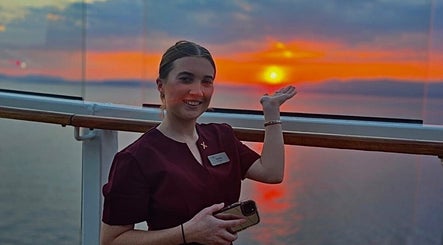 Smiling woman enjoying a sunset at Hair by Yasmin Stephens, Cross Hands, Wales, GB.