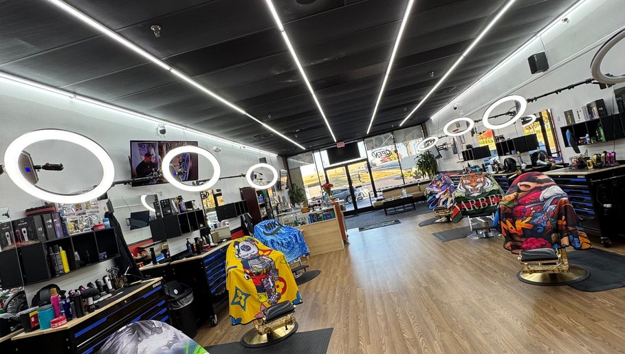 Spacious interior of Ray’s Dominican Barbershop in Roswell, Georgia, US, showcasing sleek chairs and bright lighting.