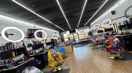 Spacious interior of Ray’s Dominican Barbershop in Roswell, Georgia, US, showcasing sleek chairs and bright lighting.