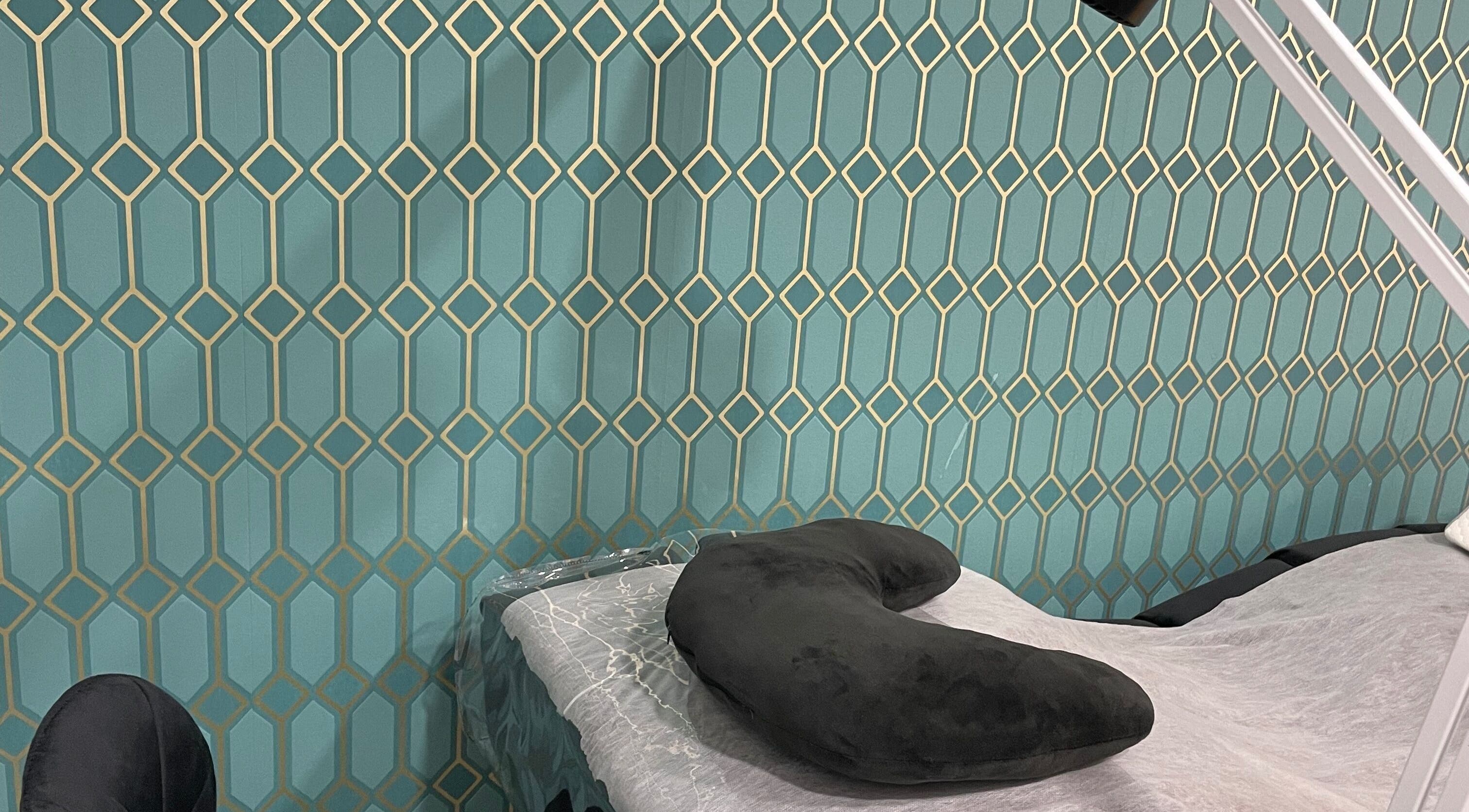 Área de tratamento em Karina Kolesya Lash, Setúbal, PT, com travesseiro preto em fundo decorativo.