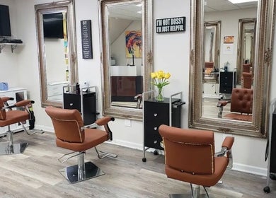 Elegant salon interior at Millie's All About You, New York, New York, US. Featuring stylish brown chairs and mirrors.