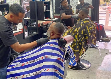 Barbers at Valentino Barbershop in Willemstad, Curaçao, CW, providing precision haircuts.