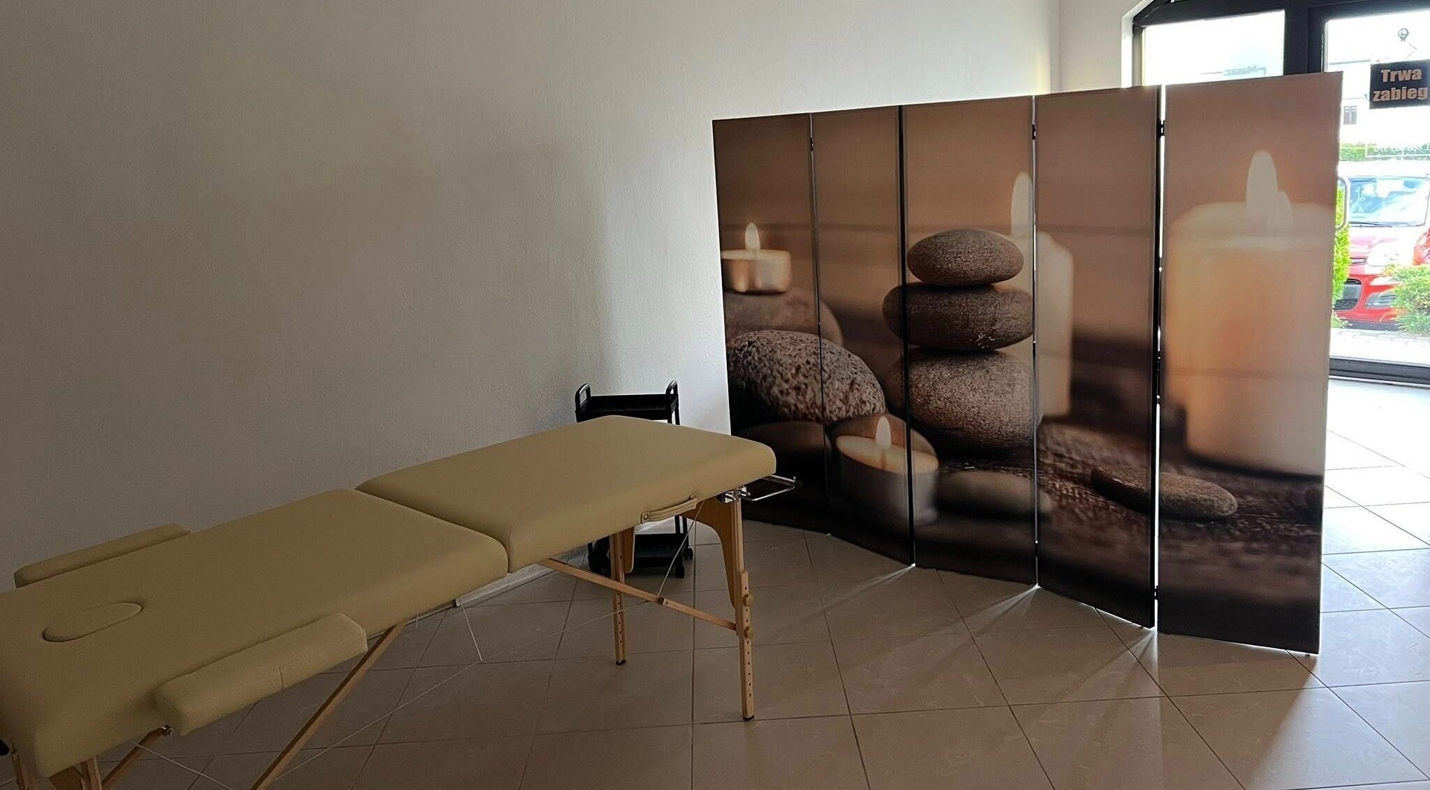 Masażowe łóżko w Przystań Relaksu, Busko-zdrój, Województwo Świętokrzyskie, PL, z relaksacyjnym parawanem.