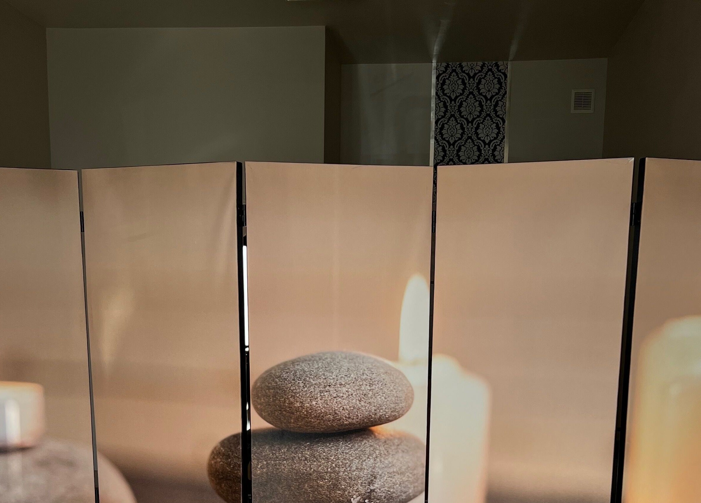 Przytulna strefa relaksu w Przystań Relaksu, Busko-Zdrój, z kamieniami i świecami.