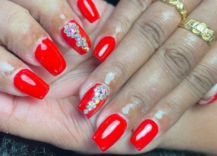 Glistening red nails with rhinestones at Cleopatra Skin & beauty Suriname, Paramaribo, Paramaribo, SR.