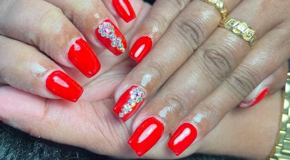 Glistening red nails with rhinestones at Cleopatra Skin & beauty Suriname, Paramaribo, Paramaribo, SR.