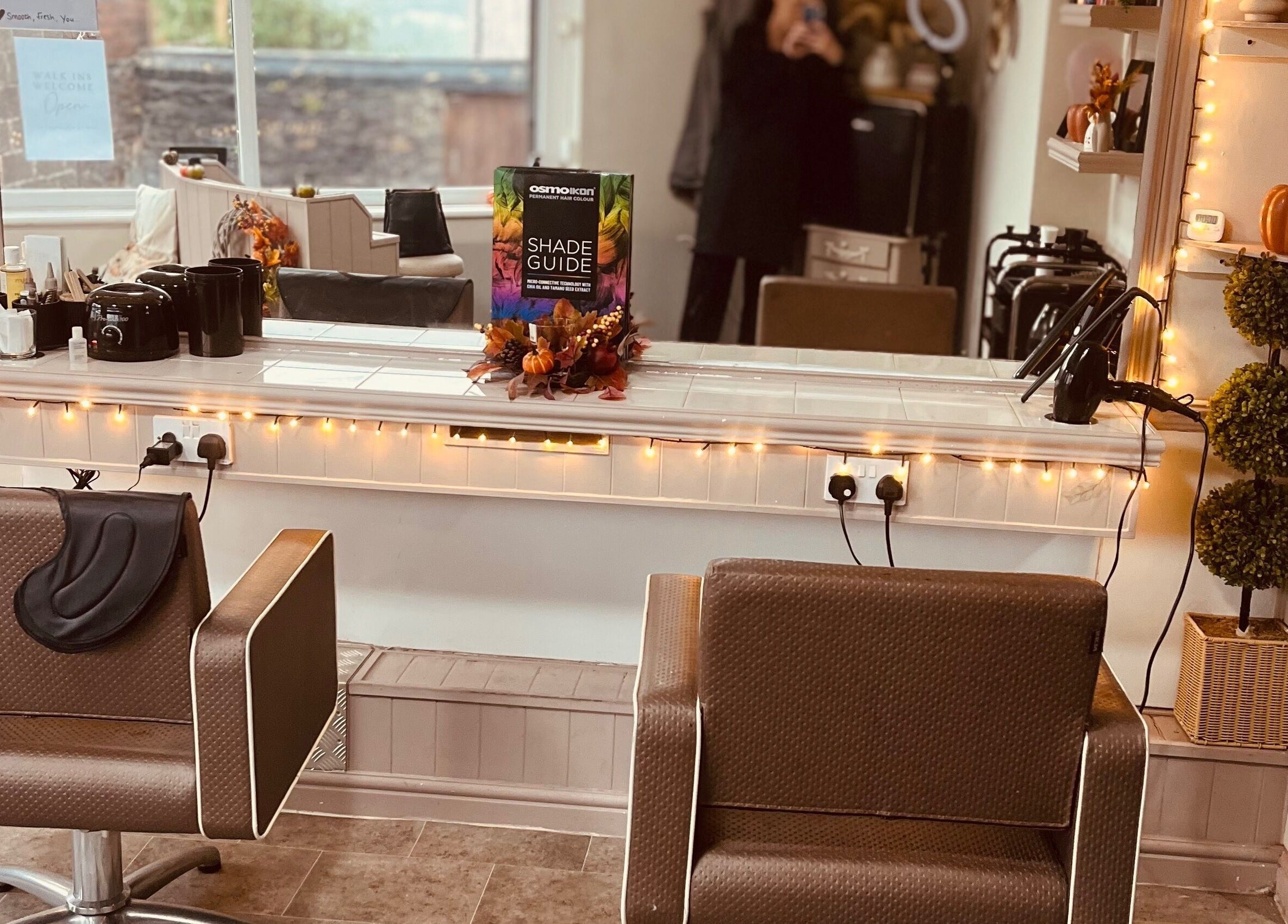 Warm and inviting salon chair at Taylormadehair in Mountain Ash, Wales, GB, set against a softly lit mirror.