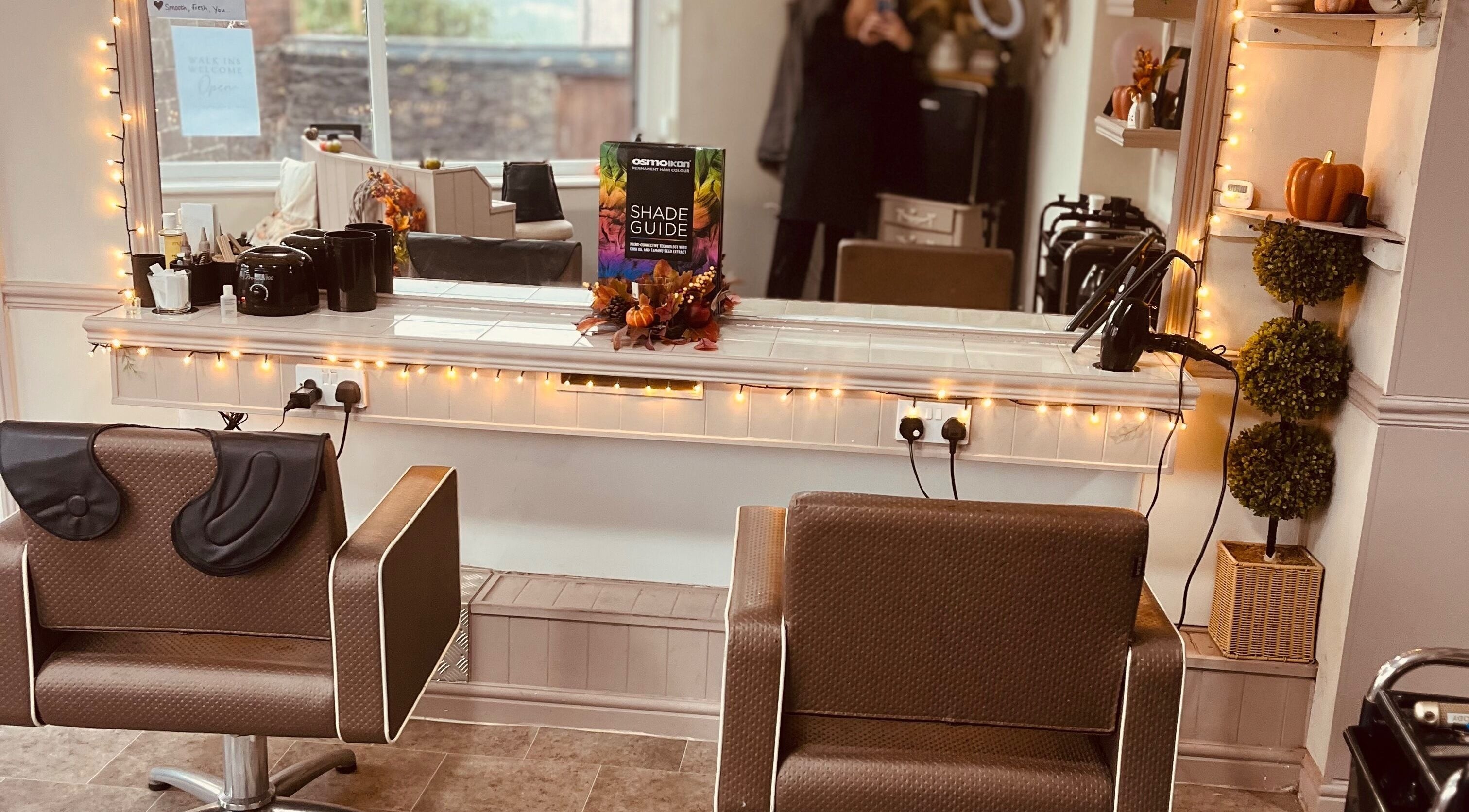 Warm and inviting salon chair at Taylormadehair in Mountain Ash, Wales, GB, set against a softly lit mirror.