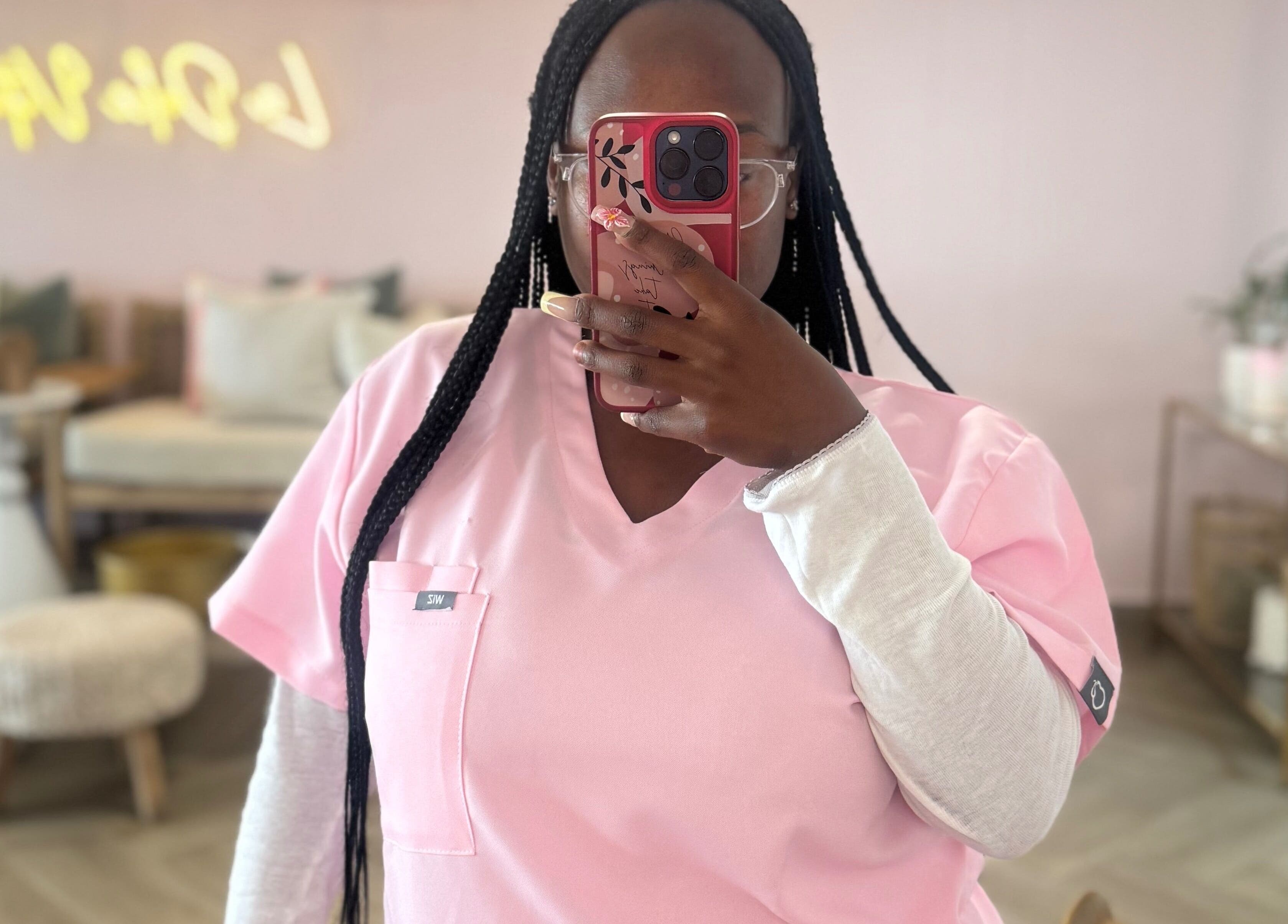 Professional at Opulent Nails in Cape Town capturing beauty ambiance in pink uniform.
