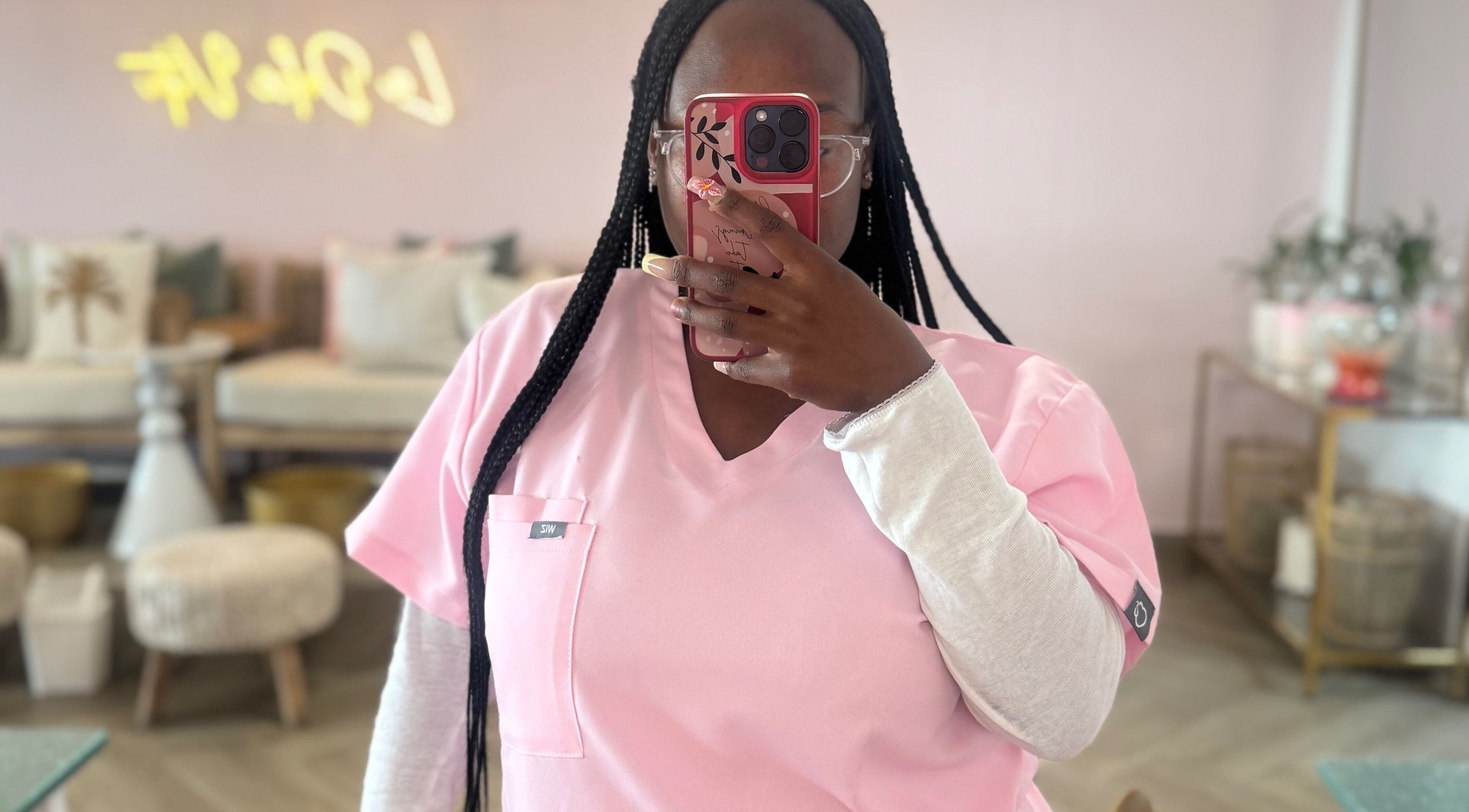 Professional at Opulent Nails in Cape Town capturing beauty ambiance in pink uniform.