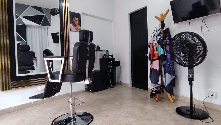 Interior moderno de LOS SANTOS BARBER SHOP en Cali, Valle Del Cauca, CO con silla y espejo decorativo.