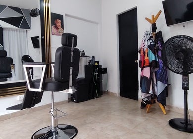 Interior moderno de LOS SANTOS BARBER SHOP en Cali, Valle Del Cauca, CO con silla y espejo decorativo.