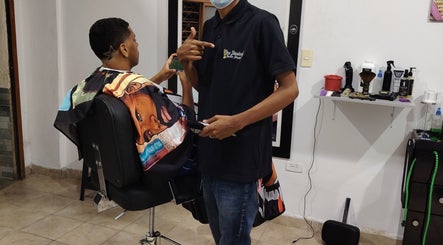 Barbero atendiendo cliente en LOS SANTOS BARBER SHOP, con diseño moderno. Cali, Valle Del Cauca, CO.