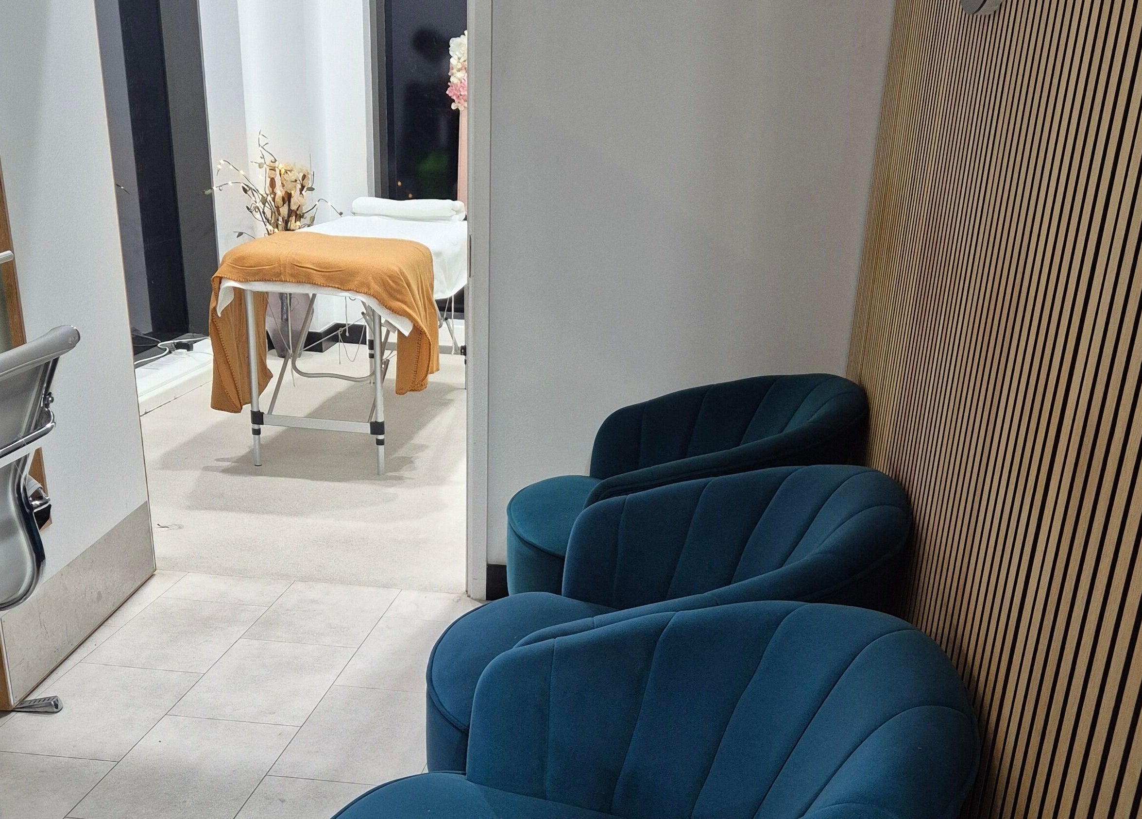 Relaxing lounge and treatment area at Aura Hair N Beauty, London, England, GB. Cozy seating and therapy table.