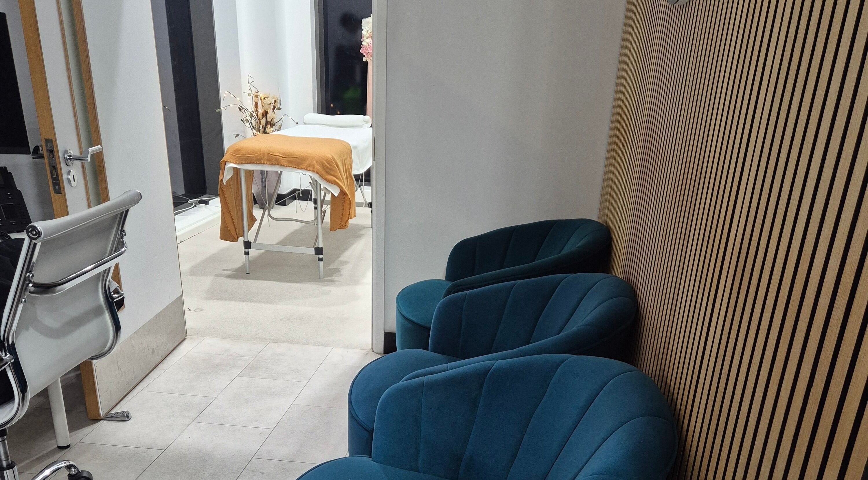 Relaxing lounge and treatment area at Aura Hair N Beauty, London, England, GB. Cozy seating and therapy table.