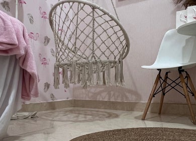Inviting seating at Flamingo Facial, Sib, Muscat Governorate, OM with pink decor and a wicker chair.