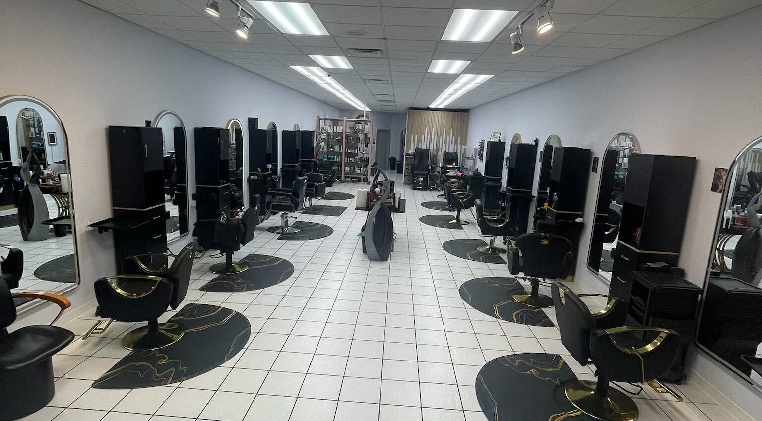 Interior of Jasmines+Hair Salon in Houston, Texas, US with sleek black styling chairs and mirrors.