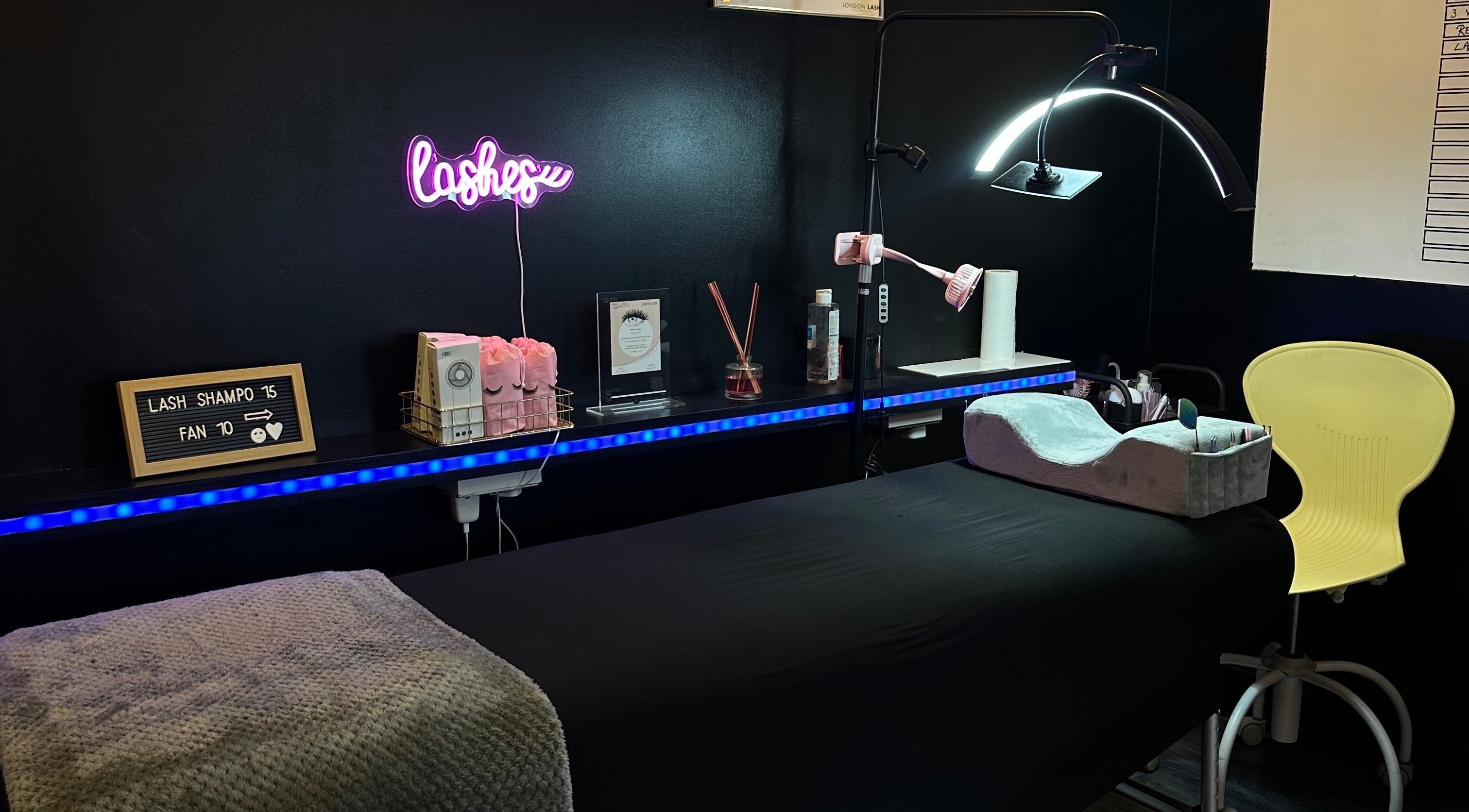 Tranquil treatment space at Lashroom_uk, Enfield, England, GB with cozy bed and neon lash sign.
