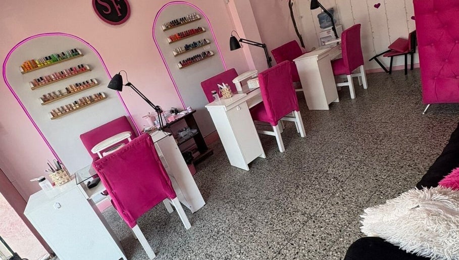 Área de manicure en SF BEAUTY STUDIO, La Tablada, Provincia De Buenos Aires, AR, con sillas rosas vibrantes.