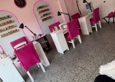 Área de manicure en SF BEAUTY STUDIO, La Tablada, Provincia De Buenos Aires, AR, con sillas rosas vibrantes.