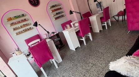 Área de manicure en SF BEAUTY STUDIO, La Tablada, Provincia De Buenos Aires, AR, con sillas rosas vibrantes.