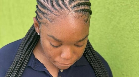 Intricate braided hairstyle at P & S salon, Windhoek, Khomas Region, NA on a vibrant background.