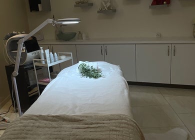 Salle de soins apaisante à l'Institut Reflet de Beauté, Bussigny, Vaud, CH, avec table de massage et plantes.