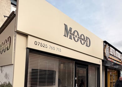 Exterior view of Deli White Massage MOOD in London, England, GB. Modern storefront with sleek signage.