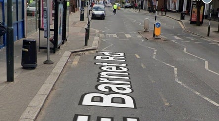 Street view near Deli White Massage MOOD in London, England, GB with a busy road and shops.