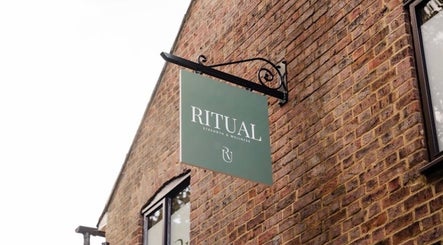 Deli White Massage RITUAL sign on brick wall in Berkhamsted, England, GB, highlighting wellness venue.