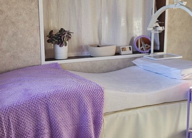 Salle de soins relaxante à Effet Déesse, Crêts En Belledonne, Auvergne-rhône-alpes, FR, avec couverture mauve.