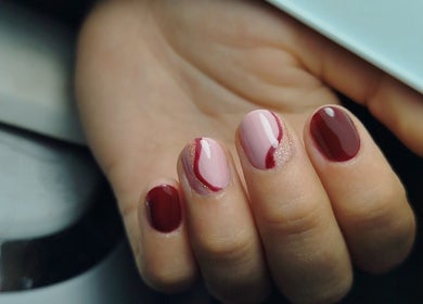 Manicura elegante en tonos rojo y rosa en MARIA RESINA BEAUTY SALON, Almería, Andalucía, ES.