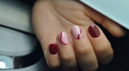 Manicura elegante en tonos rojo y rosa en MARIA RESINA BEAUTY SALON, Almería, Andalucía, ES.