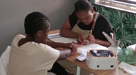Manicure session at Queen R Spa in Johannesburg, Gauteng, ZA. Nail technician perfects client's nails.