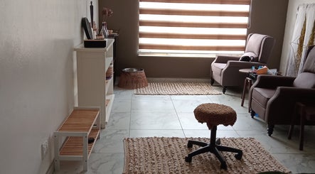 Relaxing seating area at Queen R Spa, Johannesburg, Gauteng, ZA with comfy chairs and soft lighting.