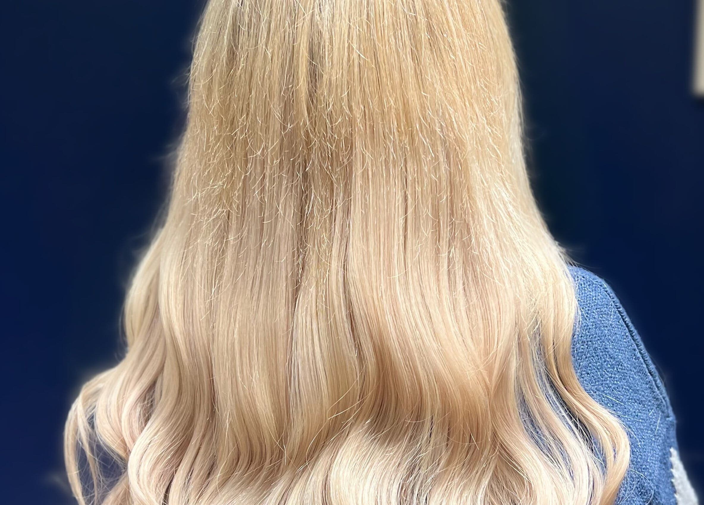 Flowing blonde hair styled at Silk & Strands, Stafford, England, GB, showcasing elegant waves.