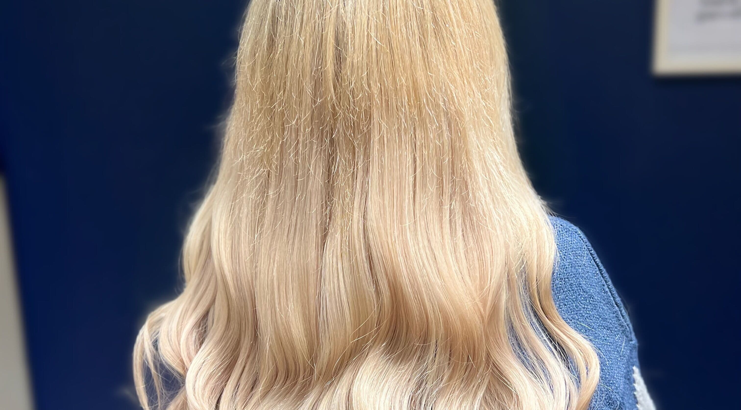 Flowing blonde hair styled at Silk & Strands, Stafford, England, GB, showcasing elegant waves.