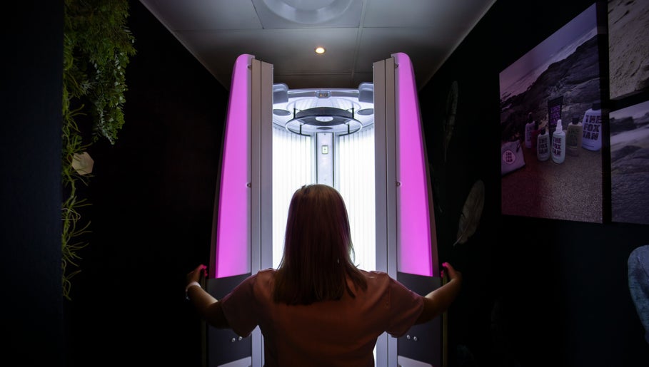 Tanning booth in Glow Studio, Roodepoort, Gauteng, ZA, with a person entering for a session.