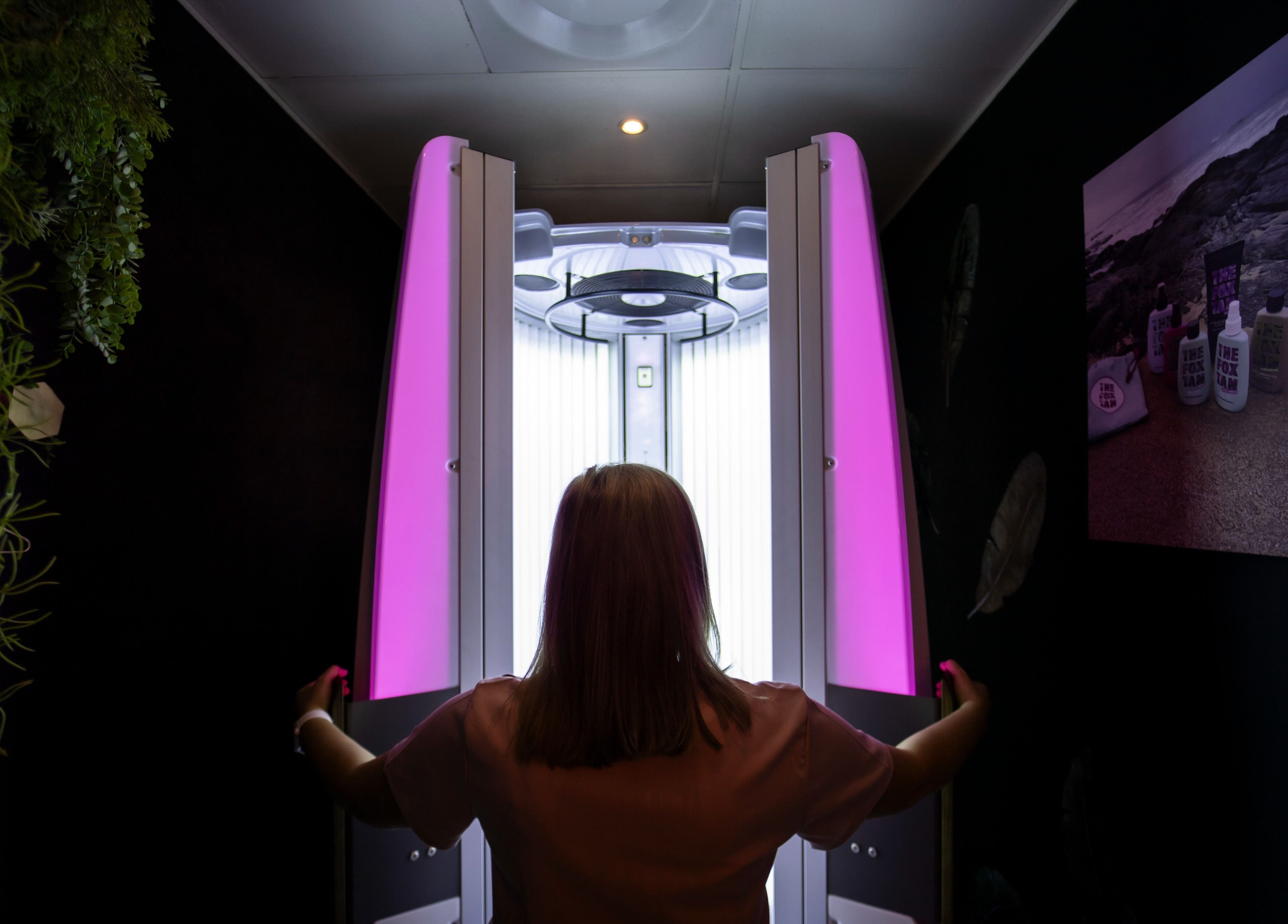 Tanning booth in Glow Studio, Roodepoort, Gauteng, ZA, with a person entering for a session.