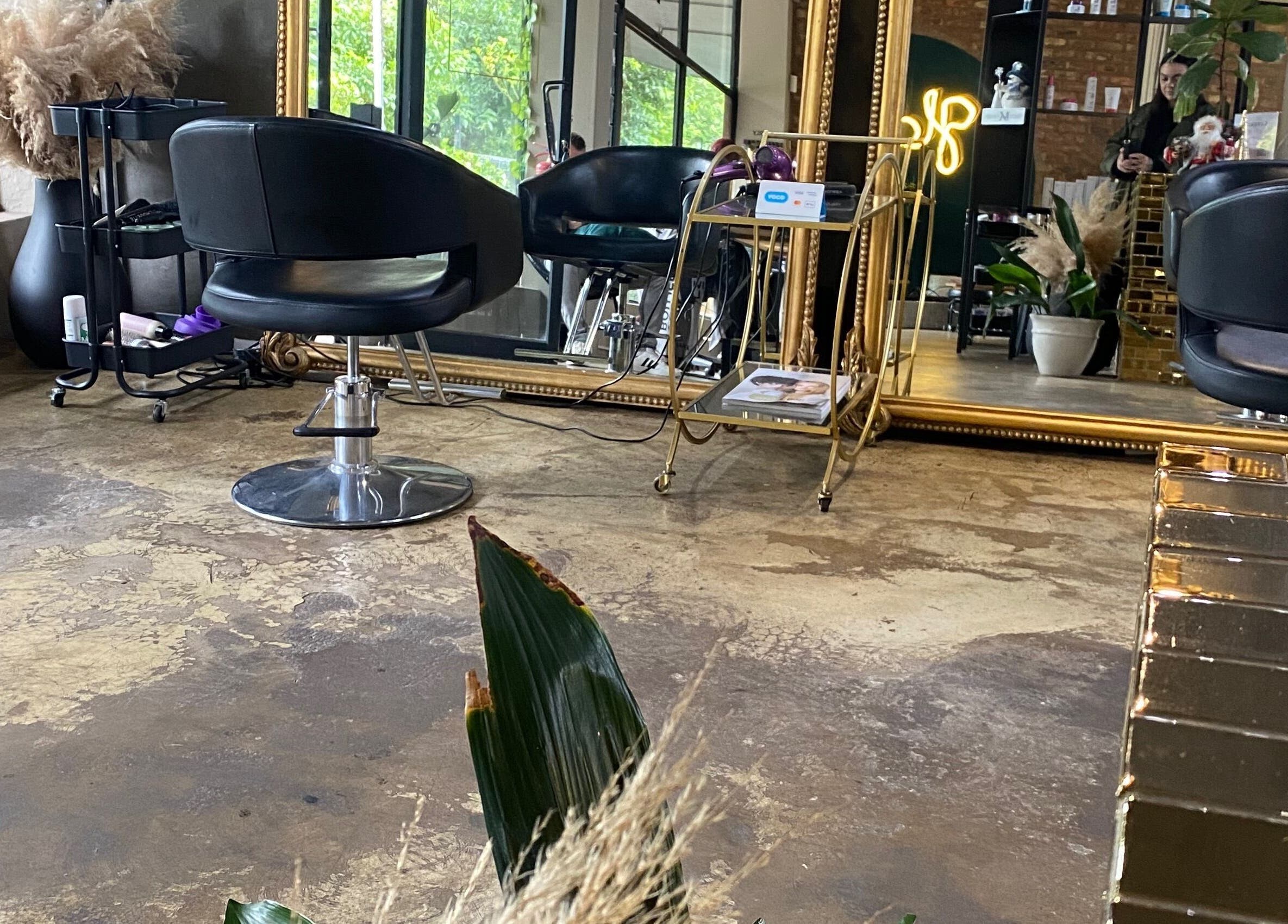 Sophisticated salon setting at Roxy At Glow, Pretoria, Gauteng, ZA, featuring modern chairs and a gold-framed mirror.