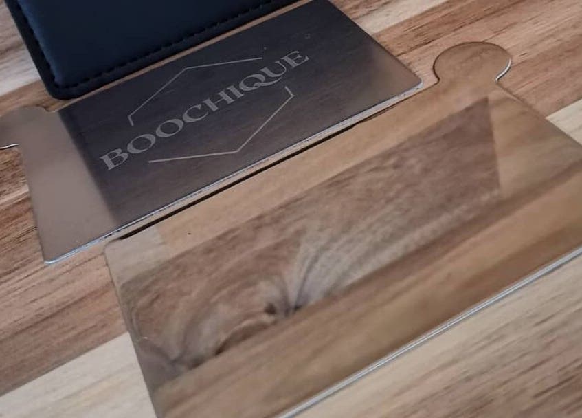 Metalen plaat met Boochique logo op houten tafel in Almere, Flevoland, NL.