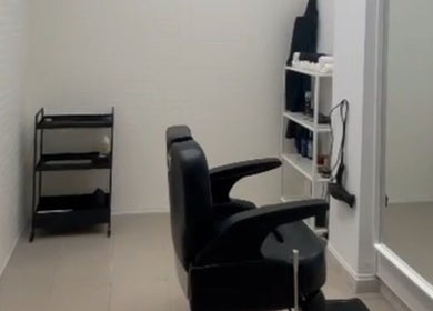 Interior moderno da Sam barbershop em Peniche, Leiria, PT com cadeira de barbear e espelho.