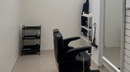 Interior moderno da Sam barbershop em Peniche, Leiria, PT com cadeira de barbear e espelho.