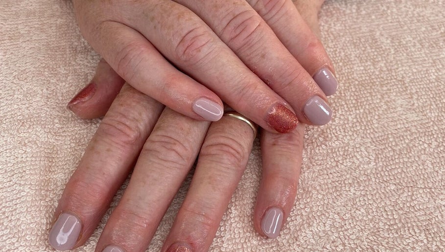 Stylish manicured hands at Amaze Beauty, Coleraine, Northern Ireland, GB on soft textured fabric.