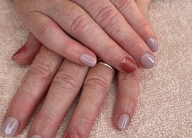 Stylish manicured hands at Amaze Beauty, Coleraine, Northern Ireland, GB on soft textured fabric.