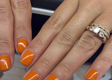Orange nail art with rings at Artistry Nail Lounge, Louisville, Kentucky, US.