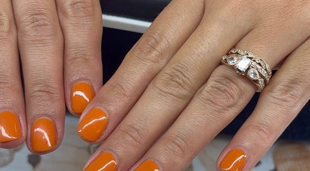 Vibrant orange manicure at Artistry Nail Lounge, Louisville, Kentucky, US showcases elegance and style.